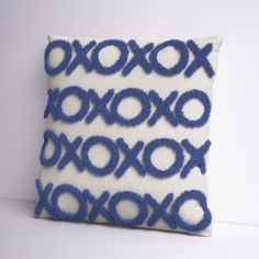 a blue and white decorative pillow with circles on it's side, sitting on a table