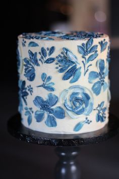 a blue and white decorated cake sitting on top of a table