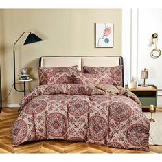 a bedroom with a bed covered in a red and white paisley print comforter set