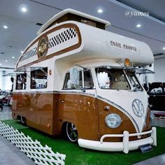 a brown and white camper parked inside of a building