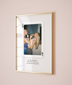 a photo frame hanging on the wall with a woman kissing a man