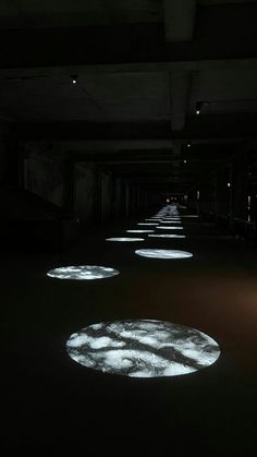 an empty room with several circular lights on the floor and in the middle of it