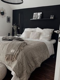 a bedroom with black walls and white bedding