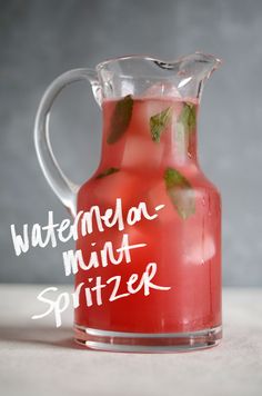 a pitcher filled with watermelon mint spritzer on top of a table