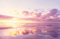 the sky is reflected in the wet sand