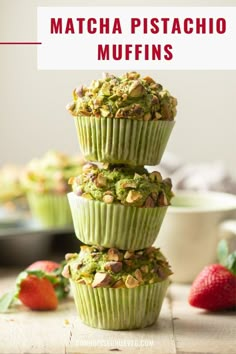 three green cupcakes stacked on top of each other with strawberries in the background