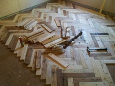 wood flooring being installed in an unfinished room with tools laying on the floor next to it