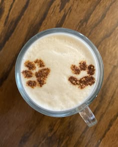 a drink with two paw prints drawn on the foam in it's glass cup