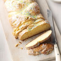 a loaf of lemon pound cake sitting on top of a cutting board next to a knife