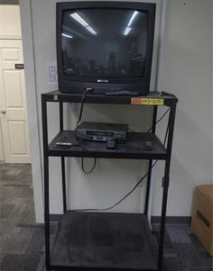 a television sitting on top of a black shelf