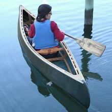 a woman sitting in a canoe on the water