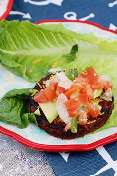 two lettuce wraps with tomatoes and avocado are on a red plate