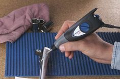 a person is using a cordless tool to fix a piece of blue material on the floor