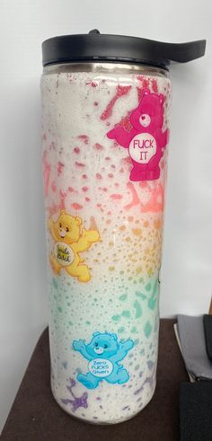 there is a cup that has been painted with different colors and bears on the side