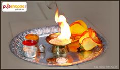 a small metal tray with some candles and other things in it on top of a table