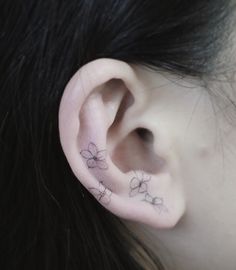 a close up of a person's ear with small flowers on the inside of it