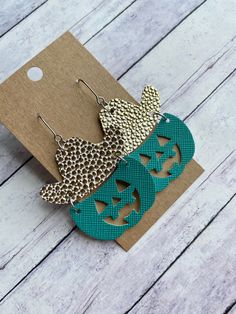 two pairs of earrings with pumpkins and leopard print on the bottom, one is green