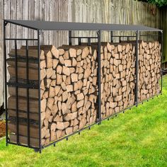 a group of logs sitting next to each other in front of a wooden fence and green grass