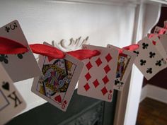 some cards are hanging on a clothes line with red ribbon and bow around the strings