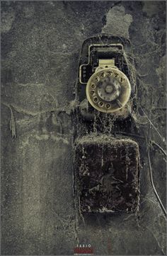 an old cell phone sitting on top of a dirty wall with water running down it