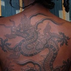 a man with a dragon tattoo on his back