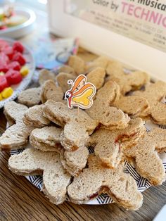 a plate full of crackers on a table with candy in the background and a sign