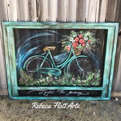 a painting of a bicycle with flowers in the basket is on display next to a fence