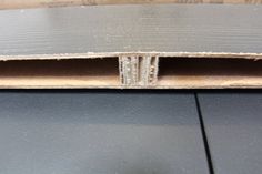 an open cardboard box on top of a black surface with the bottom section cut off