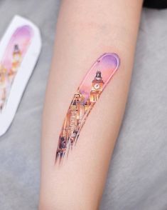 a woman's arm with a tattoo on it and a clock tower in the background