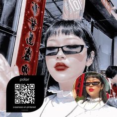 a woman wearing sunglasses and holding up a cell phone in front of a building with chinese characters on it