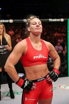 a female fighter standing in the ring with her hands on her hips