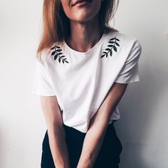 a woman with red hair wearing a white t - shirt and holding her hands together