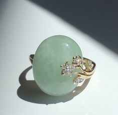 14kt Yellow Gold, Cabochon Burmese Jade and Diamond Ring. Ring Size: 6 3/4 (1) Oval Cabochon cut Jade, measuring 16.8 x 14.2 mm  (9) Round small Diamonds set along flower motif and leaf of design. Total Weight of Ring: 6.1grams Luxury Gold Jade Rings, Green Tourmaline Ring, Fire Opal Ring, Jade Ring, Tourmaline Ring, Burmese, Green Tourmaline, Oval Cabochon, Gold Style