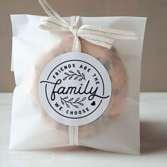 a bag filled with cookies sitting on top of a white countertop next to a tag that says friends are the family we choose