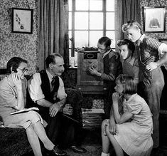 a group of people sitting around each other in a living room