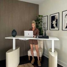 a woman sitting at a desk with a laptop