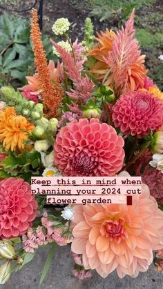 a vase filled with lots of flowers on top of a cement ground next to plants