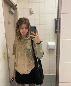 a woman taking a selfie in a bathroom mirror with her phone up to her ear