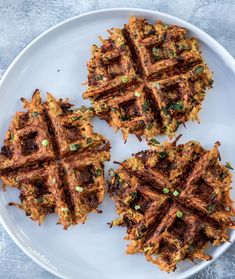 three waffles on a white plate with green onions