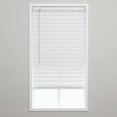 a window with white blinds in the corner