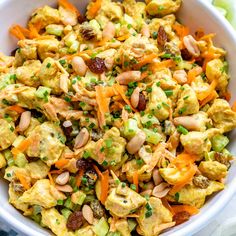 a white bowl filled with salad and nuts