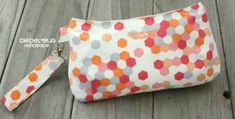 an orange and white polka dot purse on a wooden floor