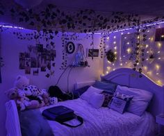 a bedroom with purple lights and stuffed animals on the bed, along with pictures hanging from the wall