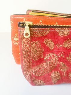 two red and gold purses sitting next to each other