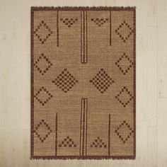 a brown rug with an intricate design on the bottom, and a cross - stitch pattern on the top