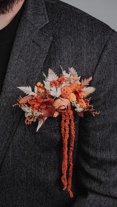 a man in a suit with an orange boutonniere on his lapel