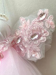 a pink dress with flowers and pearls on it