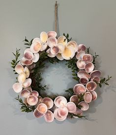 a wreath made out of seashells hangs on the wall