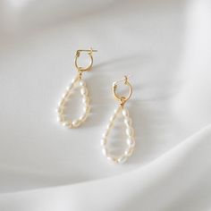 These earrings feature a dangling, teardrop shape. Made of 14K gold filled materials and genuine freshwater pearls, these earrings are tarnish-resistant, water-resistant, and hypoallergenic. Earring length measures approximately 2 inches long and can be customized shorter or longer by leaving a note at checkout. --------------------♥ PROMOS ♥-------------------- Want 10% off? Join the mailing list by visiting http://bit.ly/vedern . Just leave me a note at checkout if you have any problems applyi Gift Drop Bridal Earrings With Ear Wire, White Drop Hoop Earrings, Handmade Minimalist Pearl Drop Earrings, Handmade Minimalist Drop Pearl Earrings, White Drop Hoop Earrings For Pierced Ears, Handmade White Long Drop Teardrop Earrings, Classic White Drop Chandelier Earrings, Classic Handmade Teardrop Hoop Earrings, Everyday Drop Earrings With Pearl Charm