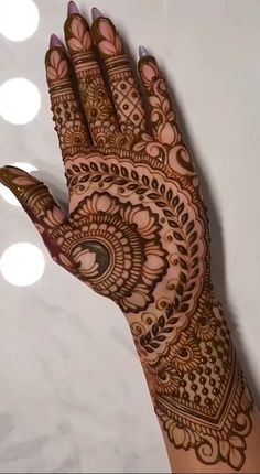 a hand with henna tattoos on it